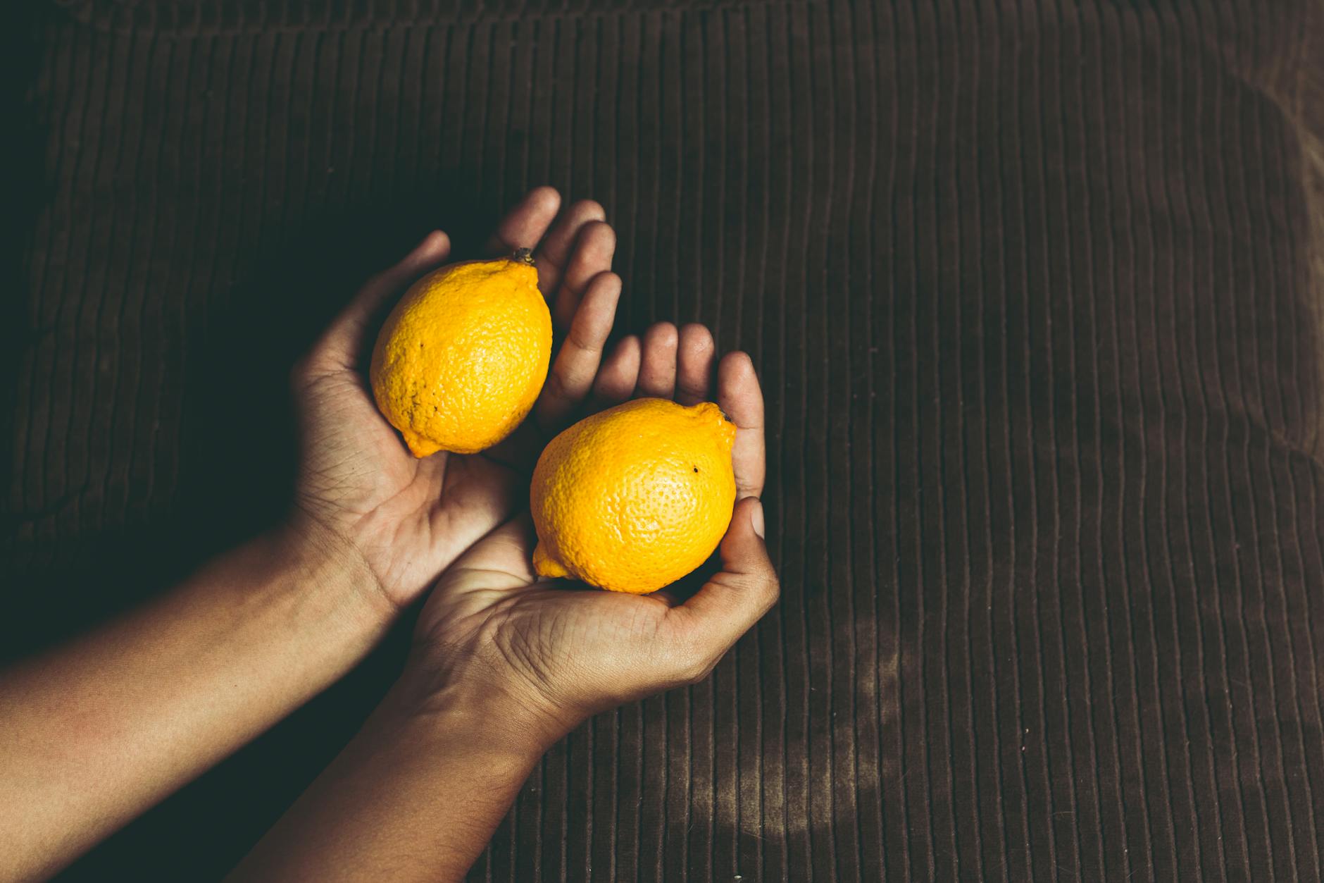 Row of bright ripe lemons arranged on a pastel background, symbolizing freshness and the lemon vibrator