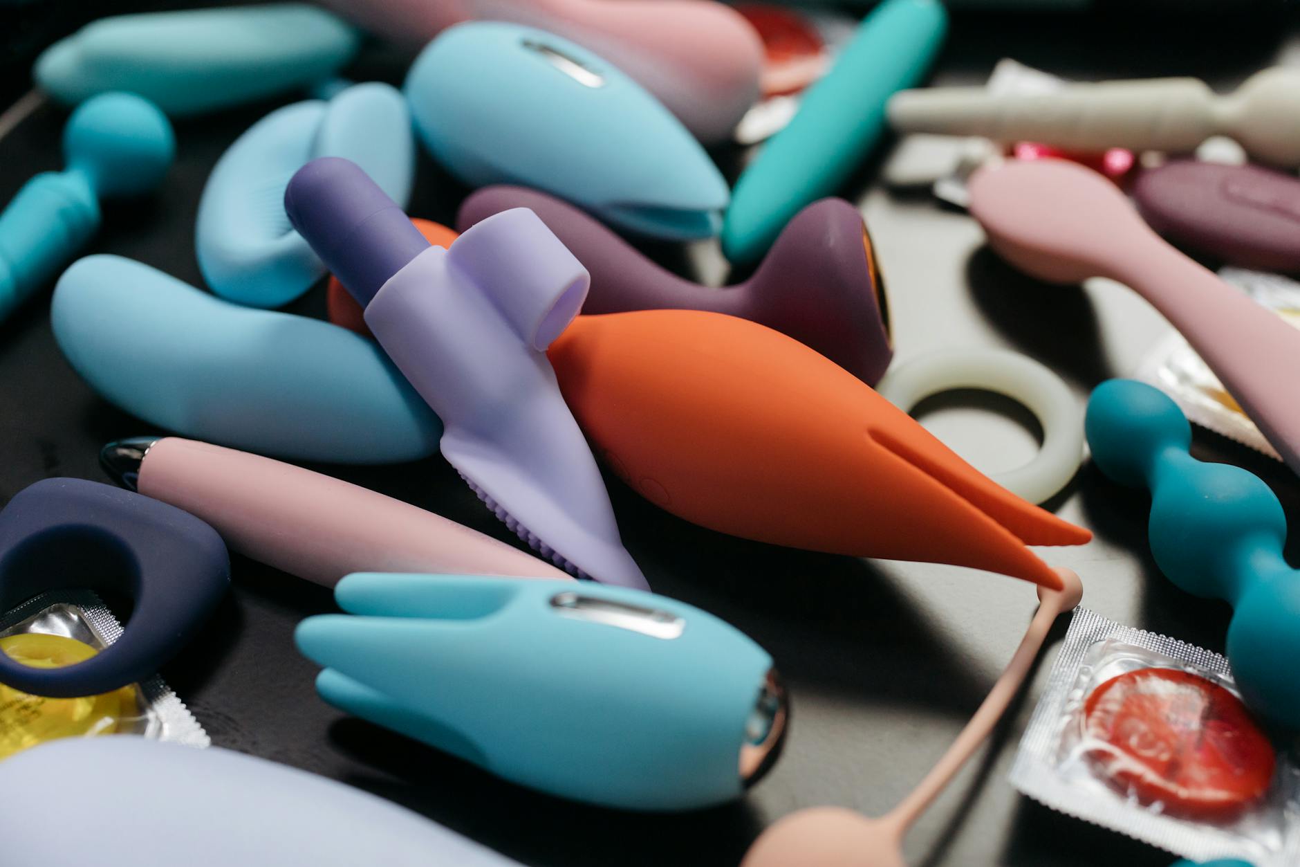 Woman holding vibrators, considering which suits her needs